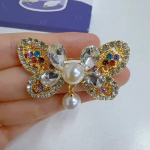 Close-up detail of an elegant vintage butterfly brooch with colorful crystals and pearls.