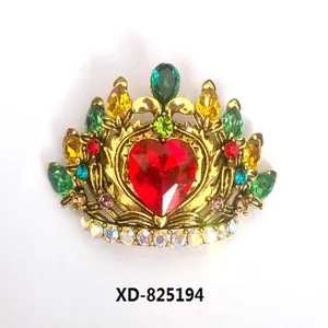 Close-up of vintage crown brooch with colorful crystals and red heart center