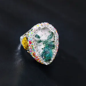 Detailaufnahme eines Vintage-Tropfenrings mit Moosstein und Strassstein-Halo-Verzierung
