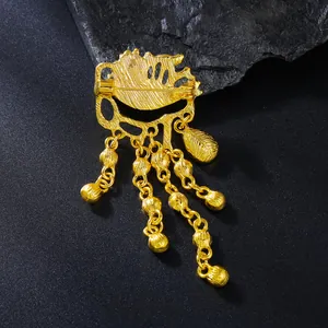 Κοντινό πλάνο χρυσής vintage καρφίτσας Evil Eye με φούντες σε σκούρο φόντο.