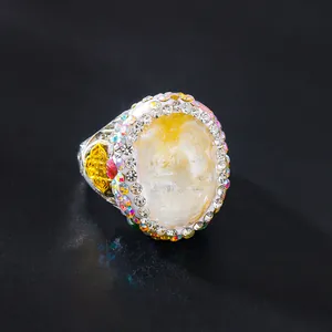 Detaillierte Makroansicht eines Retro-Rings mit großem ovalem Stein und Strass-Halo.
