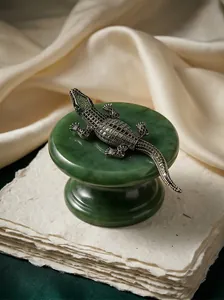 Exquisite crocodile brooch with green crystals shown on a jade stand for detailed quality.