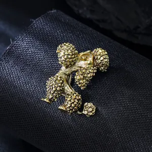 Vue détaillée d'une broche caniche dorée vintage avec texture métallique fine