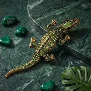Exquisite green rhinestone crocodile brooch on marble background, luxury fashion accessory.