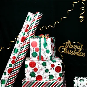 Close-up of Christmas aluminum wrapping paper rolls with red stripes and snowflake patterns.