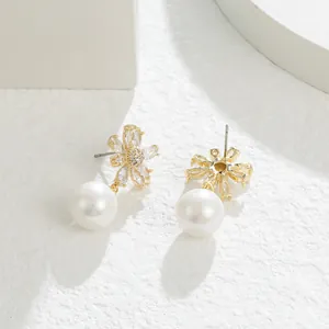 Elegante oorbellen met micro-geplaveide zirkonia bloemen en grote witte parelhanger.