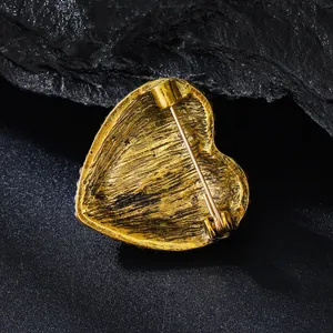 Detailed back view of a vintage golden heart brooch showing the secure pin mechanism