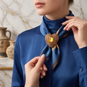 Elegant gold heart-shaped brooch with sparkling crystals and amber gemstone on model