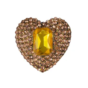 Exquisite heart-shaped brooch with a large yellow center stone and champagne rhinestones.