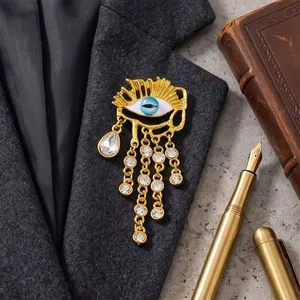 Spilla Evil Eye vintage color oro con nappe di cristallo appuntata sul bavero di un abito