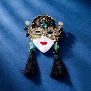 Detailweergave van een vintage koninginnenmaskerbroche met kristallen en zwarte kwastjes.