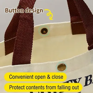 Small canvas tote bag featuring a secure metal snap button closure for daily use