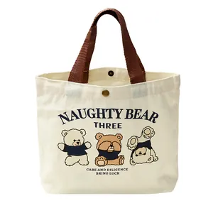 Minimalist canvas lunch tote bag featuring cute cartoon bear print and brown handles