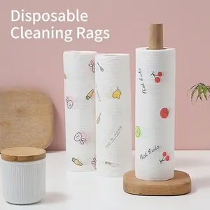 Three rolls of thick disposable kitchen cleaning rags with cute patterns on a wooden holder