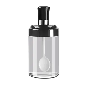 Transparent glass seasoning jar with airtight black lid and integrated white spoon