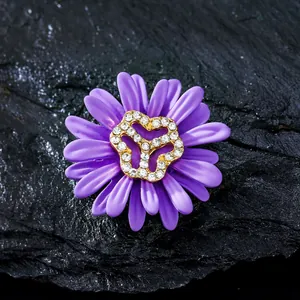 Primer plano de un elegante broche de margarita morada con centro de pedrería brillante