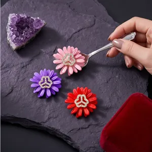 Elegantes broches de margaritas con centros de pedrería brillante en rosa, púrpura y rojo
