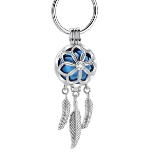 Porte-clés attrape-rêves à boule creuse argentée avec noyau bleu et pompons à plumes