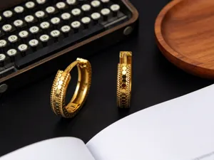 Detalle de los pendientes de aro de plata S925 con textura de escamas de pez doradas