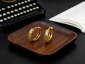 Primer plano de pendientes de aro en plata S925 dorada con textura de escamas de pez