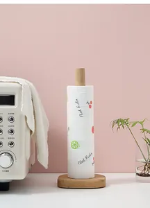 Close-up detail of disposable kitchen wipes with fruit patterns on a wooden holder stand.