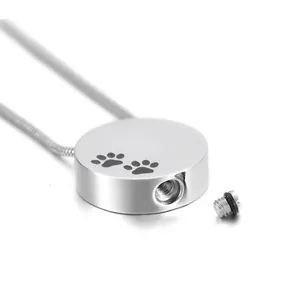 Détail d'un collier urne pour animaux rond en argent avec ouverture à vis et empreinte