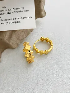 Vista dettagliata di eleganti orecchini a cerchio in oro con fini motivi intagliati