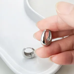 Nahaufnahme von polierten S925-Sterlingsilber-Ohrringen in Wassertropfenform in der Hand