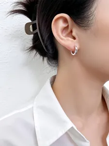 Detalle de pendientes de aro de plata S925 con diseño de escamas