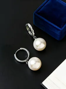 Detalle de pendientes de aro de plata S925 con elegantes perlas grandes blancas