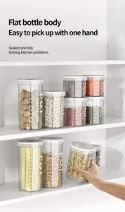 Vista detallada de varios botes herméticos para alimentos en un estante de cocina blanco.