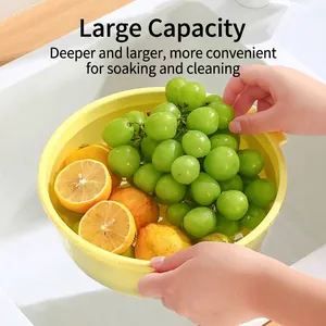 Large yellow kitchen colander bowl filled with fresh green grapes and citrus fruits