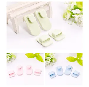 Detail of multi-colored adhesive remote control storage hooks in green, pink and blue