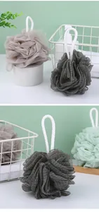 Macro view of multi-colored mesh bath shower loofahs with thick white braided hanging ropes