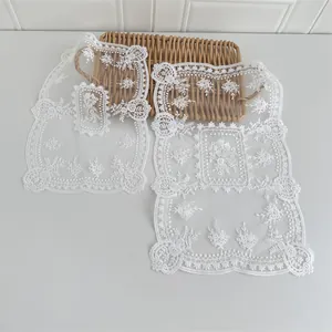 Detailansicht von zarten weißen Tischsets aus Spitze mit aufwendiger Stickerei