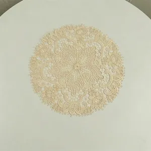 Close-up detail of an intricate beige floral lace placemat with elegant maple leaf embroidery