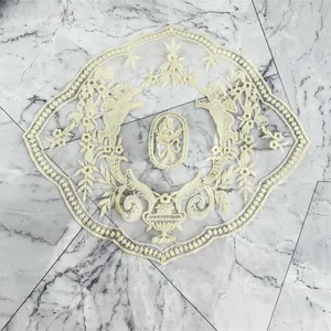 Detailed view of cream embroidered lace doily featuring cherubs and floral urn pattern