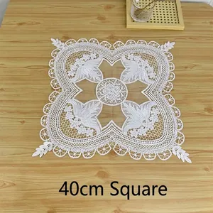 Close-up detail of white vintage embroidered lace placemat featuring intricate floral patterns