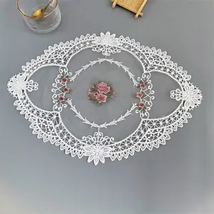 Macro detail of a white hollow lace mesh patch featuring elegant pink floral embroidery