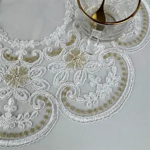 Detailed texture of white and gold floral embroidered round lace placemat cover cloth