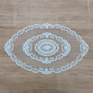 Top view of an elegant white oval lace tablecloth with intricate floral embroidery