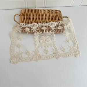 Detail der Stickerei eines cremefarbenen Tischsets aus Netzstoff im europäischen Vintage-Stil