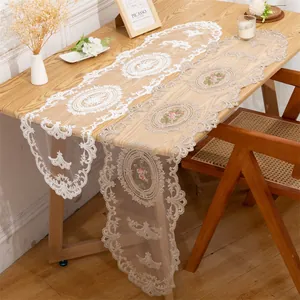 Elegant lace table runners with intricate floral embroidery on a wooden table setup