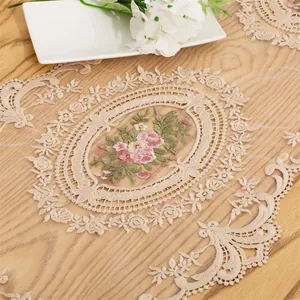 Detail shot of pink floral embroidery and lace on a mesh table runner fabric