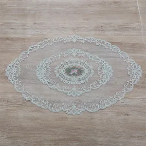 Detailed view of French lace embroidery and hollow floral pattern on oval tablecloth