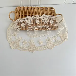 Detailaufnahme eines Vintage-Spitzen-Platzsets aus Netz mit eleganter Blumenstickerei.