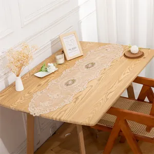 Vintage European mesh table runner with rose embroidery displayed on a wooden table