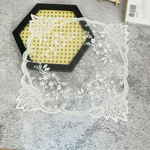 Detalle de mantel individual de encaje blanco con elegante bordado floral de estilo europeo
