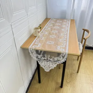 Detail shot of white lace embroidered table runner with elegant hollow design