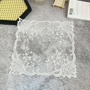 Detalle de cerca del intrincado bordado floral blanco en un mantel individual de encaje